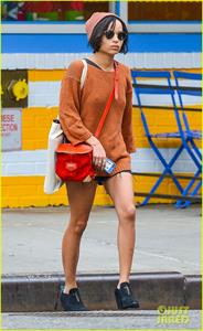 Zoe Kravitz walking in shorts and an orange top