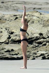 Miley Cyrus  yoga in black bikini on beach in Hawaii 1/24/13 