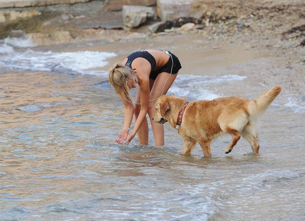 Kimberley Garner in a black bikini on the beach in St. Tropez on July 31, 2014