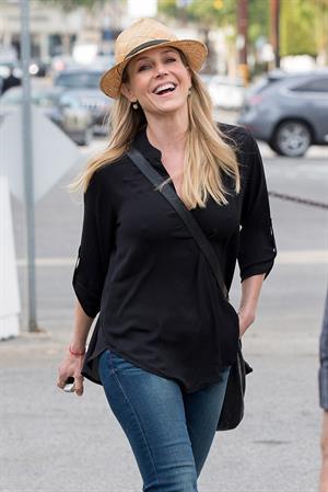 Julie Benz walking in jeans and a hat
