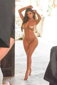 Demi Rose in a sexy gold thong bikini showing off her famous cleavage.





