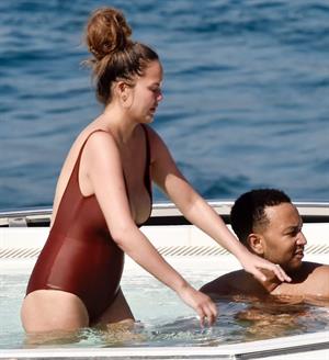 Chrissy Teigen sexy cleavage and ass in a swimsuit with her husband John Legend seen by paparazzi.

