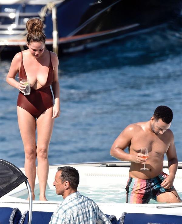 Chrissy Teigen sexy cleavage and ass in a swimsuit with her husband John Legend seen by paparazzi.
