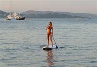 Kimberley Garner sexy model body in a pink bikini at beach seen by paparazzi.




