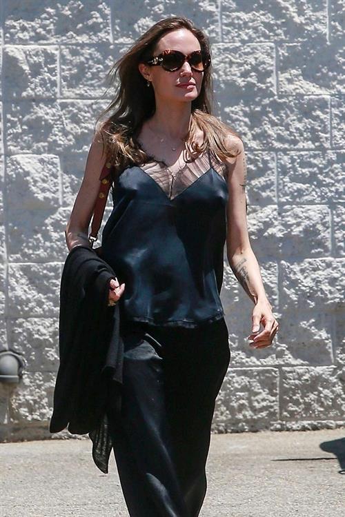 Angelina Jolie Pictures Angelina Jolie braless tits pokies in a black top seen by paparazzi showing her hard nipples.