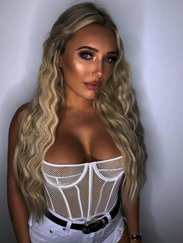 Amber Turner showing off her boobs in a see through white corset showing her tits.









