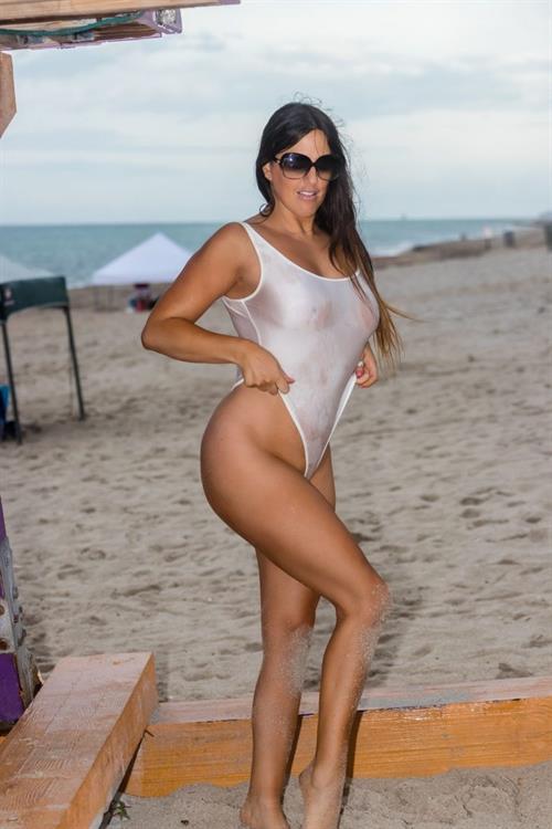Claudia Romani Pictures Claudia Romani boobs and ass in a see through white thong swimsuit showing her tits at the beach.
