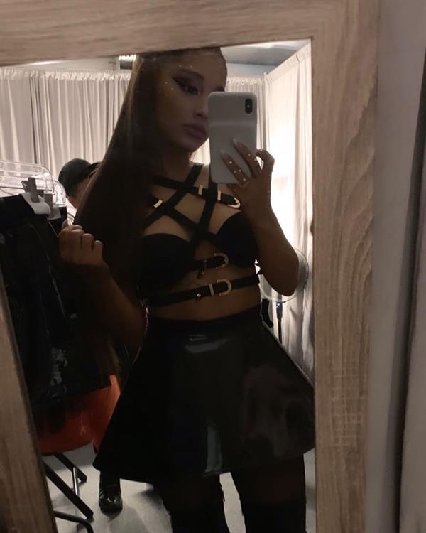Ariana Grande sexy revealing black outfit only covering her boobs and wearing a mini skirt.





















