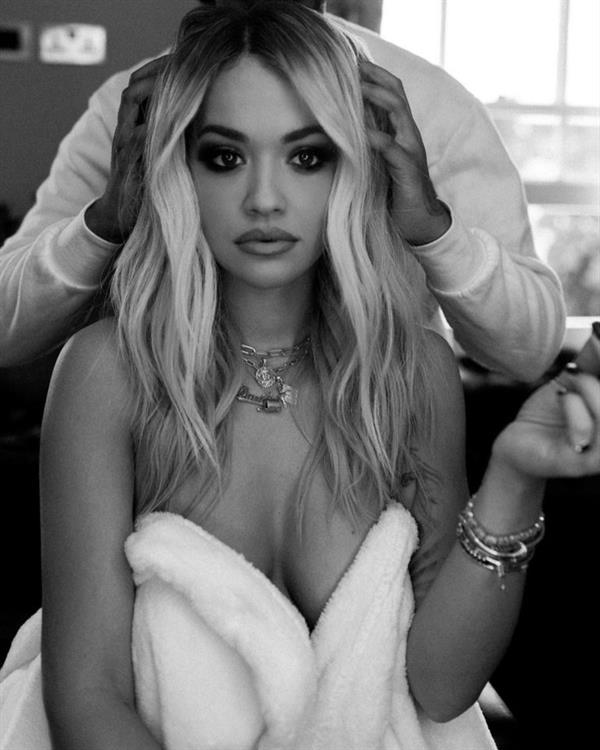 Rita Ora nude in just a robe backstage showing some nice cleavage.


