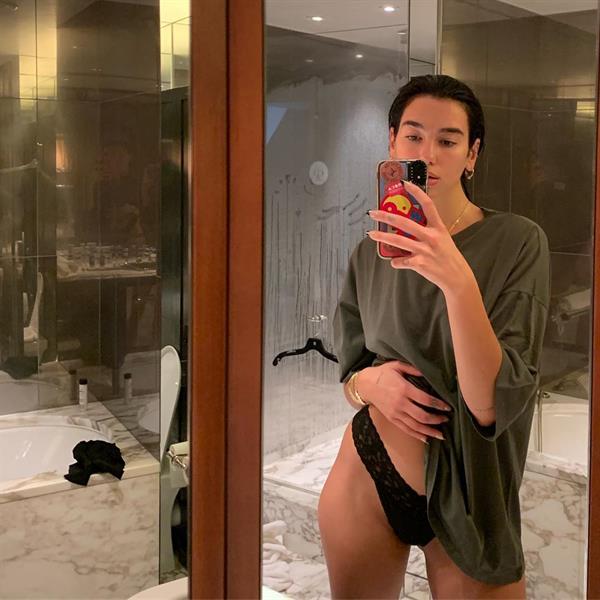 Dua Lipa in just sexy panties and a baggy shirt covering her braless boobs.








