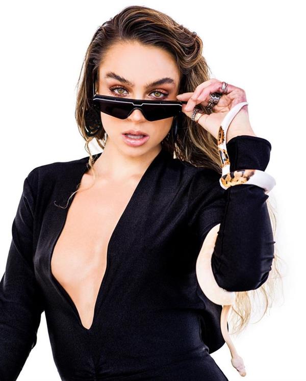 Sommer Ray braless boobs showing nice cleavage with her big tits in a low cut sexy black outfit while holding snakes.
