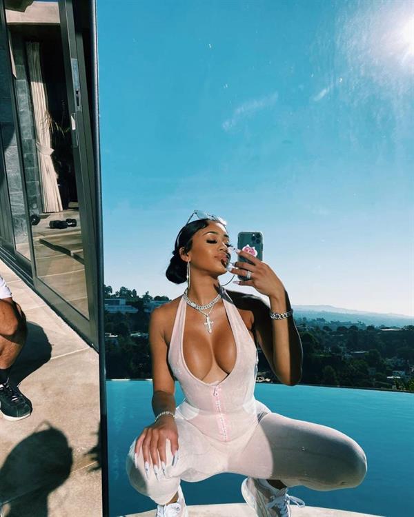 Saweetie braless boobs showing nice cleavage with her big tits in a sexy little low cut top posing in front of her pool.