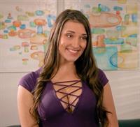 Julia Bertin displaying her impressive cleavage in a low-cut purple top.