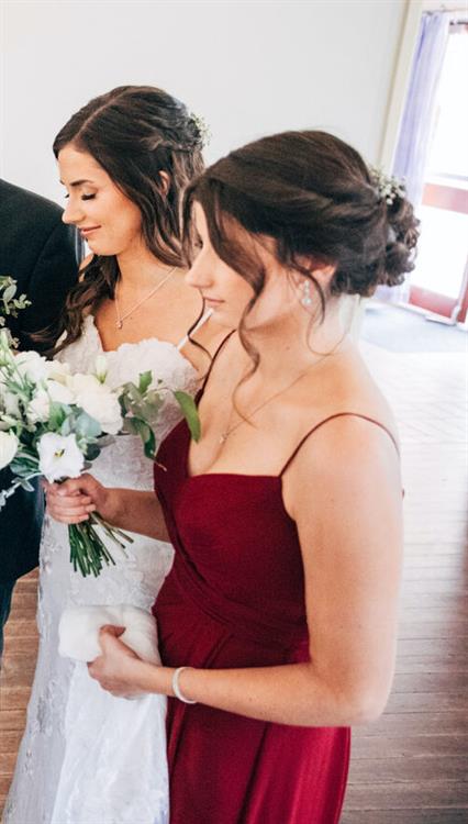 Caitlin showing off her cleavage in a low-cut red dress, alongside her sister Jess.