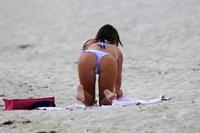 Claudia Romani in a purple thong bikini at the beach